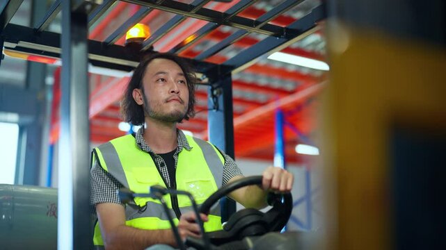 Focused warehouse worker in a safety vest operating a forklift in an industrial warehouse, ensuring efficient material handling.