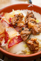 angle view clay pot rice of pork ribs and preserved meats and Chinese style sausage and cabbage vertical composition