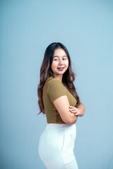 Obraz premium Portrait of a confident Asian woman smiling, standing looking at the camera isolated on a blue background