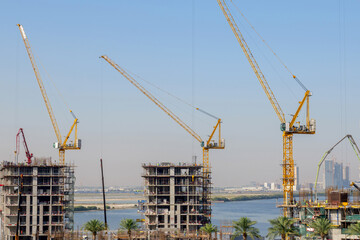 residential buildings under construction with cranes at construction site