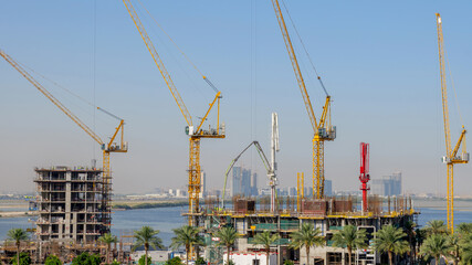 Fototapeta premium residential buildings under construction with cranes at construction site