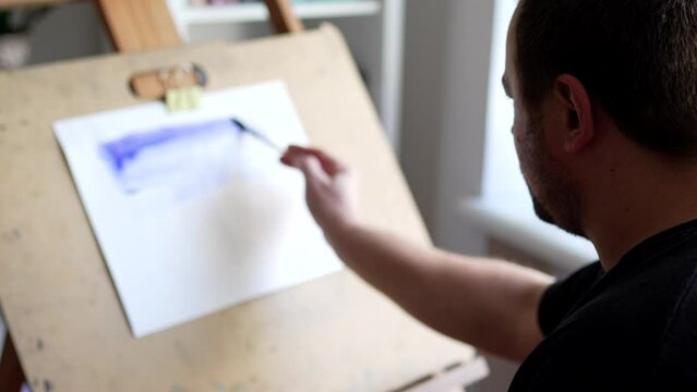 Man paints with watercolor paintings. Artist concept video.