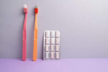 Colored toothbrushes on a color background. Replace your old toothbrush with a new one. Old and new toothbrushes. Dental health and hygiene concept