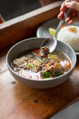 Sop Buntut or oxtail soup on a wooden table. traditional Indonesian culinary delights