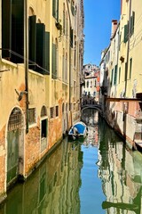 Reflection on the canal with boat at sunset in Venice, Italy