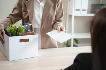 Unemployment ,jobless crisis, worker layoff concept, Close-up of young businessman pack stuff off the desk and holding boxes of self stuff when quitting the job after send resign letter from company