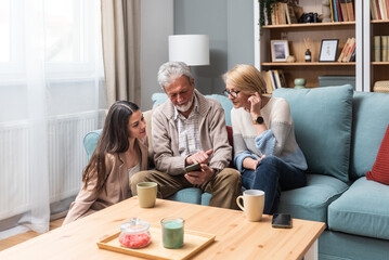 Simple living Mother father and daughter enjoying lovely time together at home. Senior couple and...