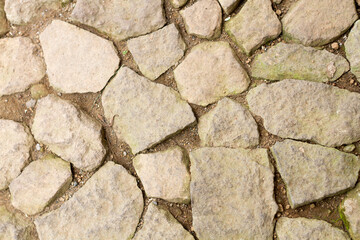 street with retro vintage stones. cobble paving stone background for walking. Cobblestone road in the sun