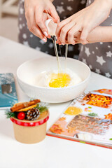 The process of cracking a hen's egg in the hands of a child and a mom, making baking dough for Christmas baking, sharing time together as daughter and mom.