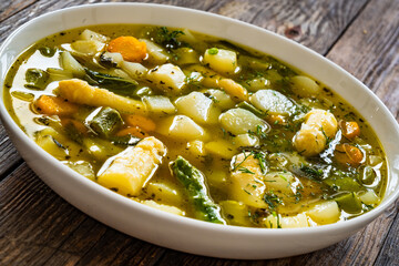 Asparagus soup in white bowl on wooden table
