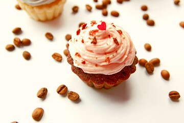 Many yummy cupcake on coffee beans birthday celebration background. Cupcake yummy pink buttercream on table. Tasty sweet chocolate cupcake, sprinkles & hearts on pink cream. Cupcake for valentine day