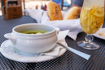 Spinach soup,ginger drink and bun on restaurant table, dining.