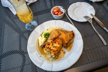 Baked chicken leg,pastry stuffing and mashed potato, drink on table.