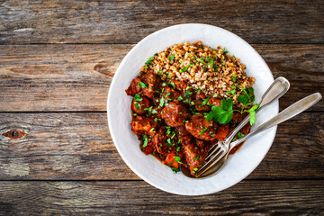 Roast beef with buckwheat groats and carrots served on wooden table
