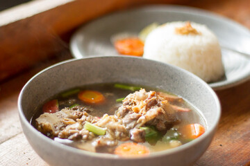 Sop Buntut or oxtail soup on a wooden table. traditional Indonesian culinary delights