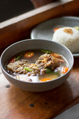 Sop Buntut or oxtail soup on a wooden table. traditional Indonesian culinary delights