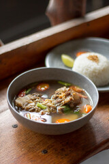 Sop Buntut or oxtail soup on a wooden table. traditional Indonesian culinary delights