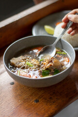 Sop Buntut or oxtail soup on a wooden table. traditional Indonesian culinary delights