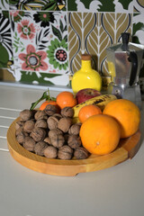 piatto in legno con noci con frutta di stagione