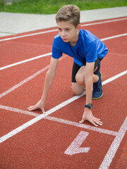 An athlete stands on the starting line at the stadium.