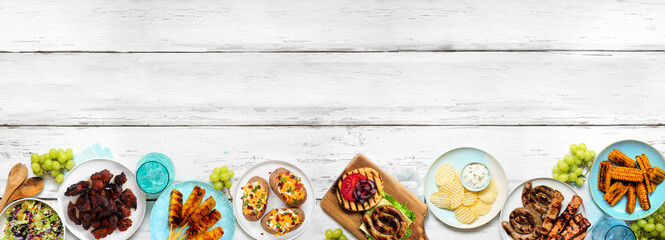 Summer BBQ or picnic food bottom border. Burgers, grilled meats, potatoes, smoked corn, fruits, salad and snacks. Top view on a white wood banner background. Copy space.