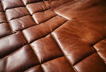 Brown smooth leather seats for customers to sit on in a cafe booth