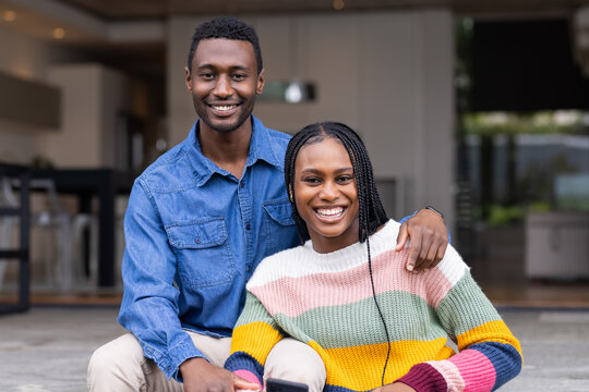 Smiling and sitting together, young African American couple enjoying time at home