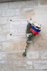 Un bouquet de fleur sur une plaque commémorative à un résistant mort pour la libération de...
