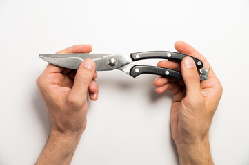 worker holds a pruner with black handles on a white background, close-up. garden tools