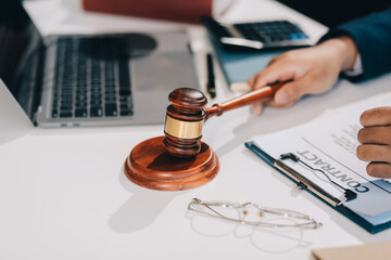 Male lawyer working with contract papers and wooden gavel on tabel in courtroom. justice and law...