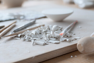 Top view on just finished work process of ceramic handicraft. A lot of tools and clay products on the table	