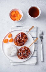 Tsukune, Japanese Chicken Meatball in teriyaki sauce with sesame seeds sprinkles with rice and vegetables in a plate