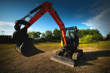 Close-up wide angle image of an excavator working on an agricultural farm in a forest belt