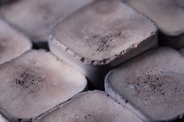 Cushion-like squares with a textured surface in soft, neutral tones. The intricate details and subtle color variations create a calming and visually engaging pattern.