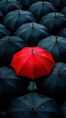 A striking red umbrella stands out among a sea of black umbrellas, symbolizing individuality and uniqueness in a crowd.