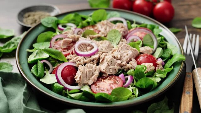 Canned tuna salad with tomatoes lambs lettuce corn salad and onions, stock video 4k