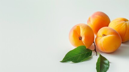 Apricots with green leaves on a white background. Copy space.