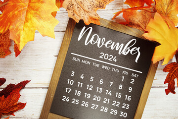 November 2024 monthly calendar maple leaf decoration on wooden background