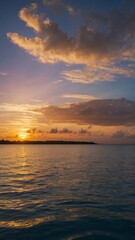 Obraz premium Sun sets over tranquil ocean, casting warm golden glow across water, sky. Horizon lined with silhouette of distant land, while sky adorned with scattered clouds reflecting hues of orange, pink,.