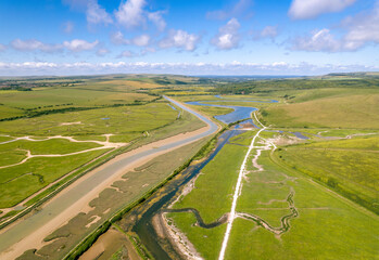 The drone aerial view of Cuckmere River. The Cuckmere River rises near Heathfield in East Sussex, England on the southern slopes of the Weald. 