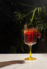 a glass with a red berry cocktail into which cherries fell and there was a spectacular splash. nightlife, alcoholic cocktail. Cherry red drink.