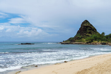 Fototapeta premium Beautiful beach, mountain backdrop, waves crashing on sandy shore