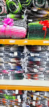 Shelves of stacked falsa Mexican blankets. Mexican textiles. Folded blankets.