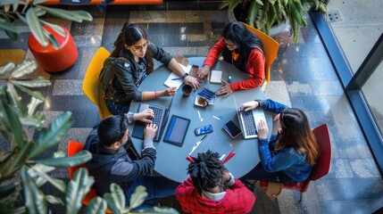 Diverse group of young professionals in casual clothing engaged in a collaborative discussion around a table in a modern office space. AIG535