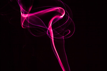 Obraz premium Abstract pink smoke on a black background, creating a fluid and dynamic pattern.