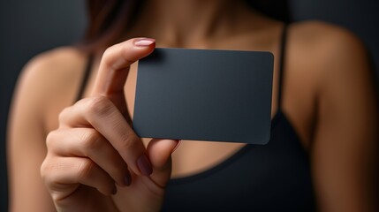 Obraz premium Female Hand with Black Business Card. Minimalist and Elegant Design.