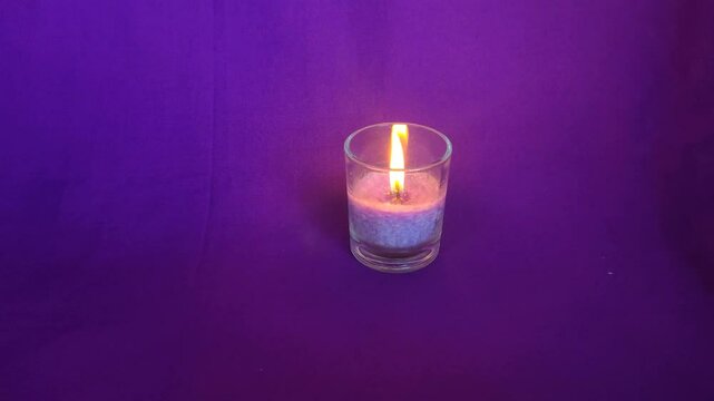 Aromatherapy candles in clear glass jars burn in the room, dark blue background for relaxation