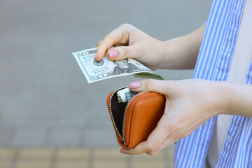 Woman holding purse with banknotes outdoors, closeup. Space for text