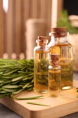Essential oil in bottles and rosemary on table