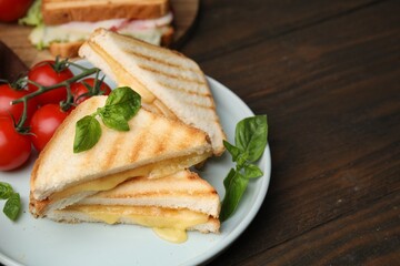 Pieces of toasted bread with melted cheese served on wooden table, space for text